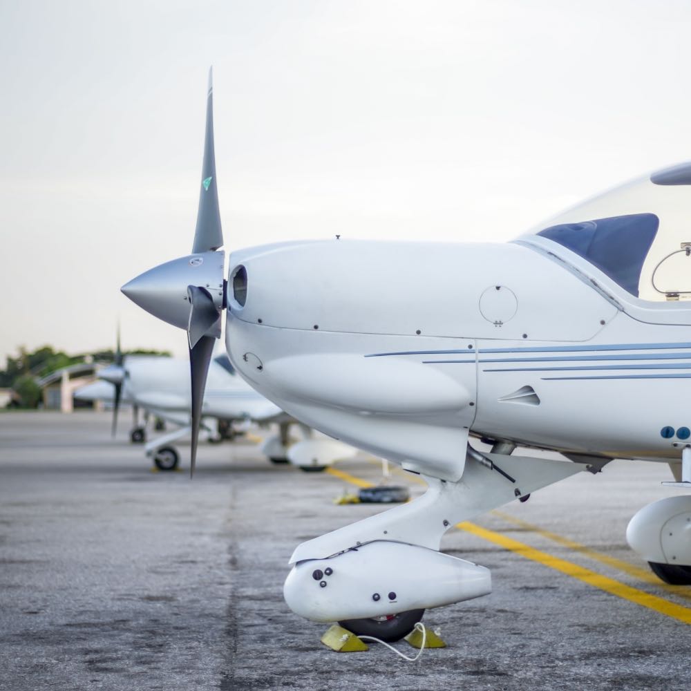 Three piston single aircraft lined up on the ramp