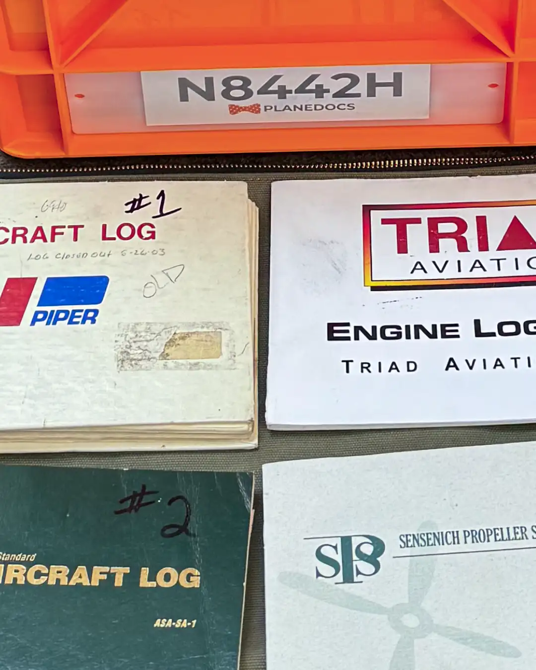 Piper aircraft logbooks laid out in an orderly manner